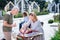 Beaming blonde-haired woman wearing beautiful white dress selling her old staff