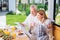 Beaming couple reading news after eating breakfast and drinking orange juice