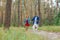 Beaming couple running in forest together with their dog
