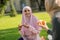 Beaming dark-eyed muslim student eating pizza with best friend