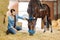 Beaming dark-haired female rider visiting her lovely horse