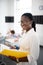 Beaming dark-skinned primary school teacher holding notebook