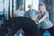 Beaming elderly woman leaning on huge tire at gym