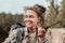 Beaming female hiker feeling cheerful while meeting her friend in mountains