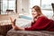 Beaming good-looking lady with light hair laying on covered bed