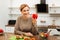 Beaming mature lady leaning on wooden table in kitchen