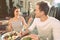 Beaming pleasant couple eating healthy food on summer terrace