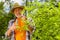 Beaming retired man getting satisfaction while cutting branches