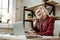 Beaming short-haired blonde businesswoman in red jacket having online call