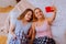 Beaming sister with tattoo on her hand making selfie with sister