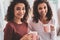 Beaming sisters drinking hot cocoa on cold winter evening