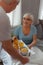 Beaming woman taking a tray with breakfast from her spouse