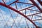 Beams of a red arched bridge close-up against a blue sky. texture of the lattice of the parts of the steel bridge. cropped