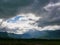 Beams of sunlight shining through dark rainy clouds  after rain down on the earth