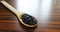 Beans spoon. Wooden spoon with black beans on the wooden rustic table. Brazilian food