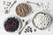 Beans, three types of beans in plates on a background of a white wooden table, vintage spoons and fork