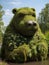 A bear statue made of moss and plants, AI