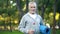 Beard grandfather in sportswear holding yoga mat and bottle of water, health