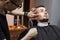 Beard haircut in a barbershop, a young guy shaving his beard with a razor, close-up