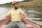 Bearded adult man rowing oars while sitting in a boat