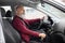 Bearded aged businessman driving luxury car, shot inside vehicle