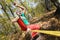 A bearded aged man sits on a slackline balancing in meditation. Professional tightrope walker in the autumn forest