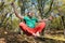 A bearded aged man sits on a slackline balancing in meditation. Professional tightrope walker in the autumn forest