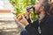 Bearded Asian man drinking coffee with hot dog