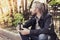 Bearded Asian man sitting on sidewalk in park