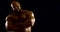 A bearded bald brutal male bodybuilder with a naked inflated torso, he is in the Studio on a black background, Posing