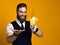 Bearded barman with beard holding cocktail in waistcoat