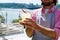 Bearded barman holding glass of cold drink in his hand