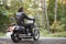 Bearded biker in black leather jacket on modern motorcycle on country roadside.