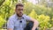 Bearded blogger in blue shirt with microphone talks in park