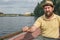 Bearded boatman in a hat on the river in a boat