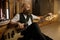 Bearded brutal guitarist tuning his musical instrument while sitting on floor