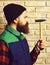 Bearded builder man holding hammer serious face