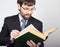 Bearded businessman in a business suit and tie, reading a thick book