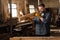 bearded carpenter in protective gloves checking wooden plank