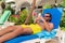Bearded Caucasian man with sunglasses using smartphone on a sunbed in a resort