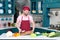 Bearded Chef in cap holds cutting wooden board in hands