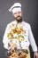 Bearded chef flipping vegetables in a frying pan