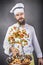 Bearded chef flipping vegetables in a frying pan