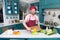 Bearded cook cutting yellow paprika. Smiling guy in cap makes salad with paprika.