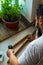 Bearded craftsman wearing a protective face mask skillfully drilling pieces of a wooden planks while working at home