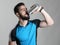 Bearded cyclist drinking water from sporty container
