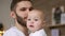 Bearded dad kissing baby. Close up of happy father with child on hands. Baby touching wrist watch on father hand.