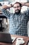 Bearded dark-haired man feeling relieved having coffee break