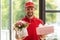 Bearded delivery man holding flowers and