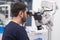 Bearded doctor looking in modern dental microscope to check cavity of patient